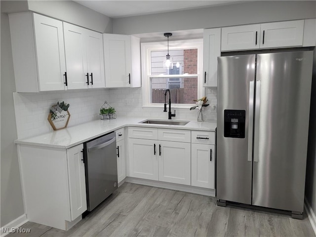 kitchen featuring sink, white cabinetry, stainless steel appliances, and light wood-type flooring