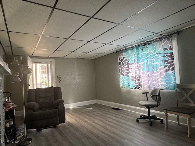 sitting room with wood-type flooring and a paneled ceiling