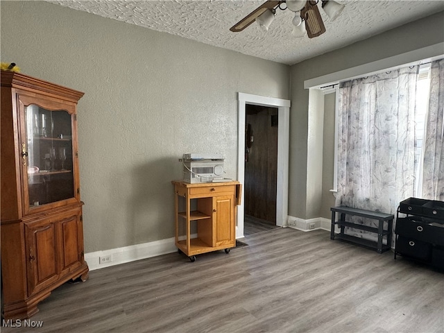 home office featuring ceiling fan, wood-type flooring, and a textured ceiling