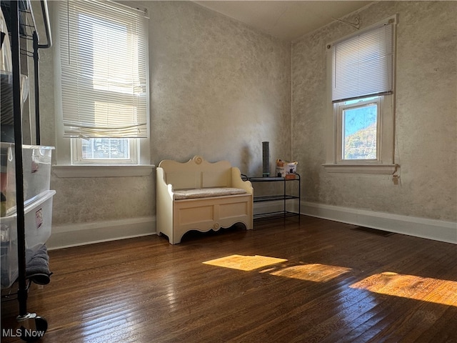 sitting room featuring dark wood-type flooring and a healthy amount of sunlight