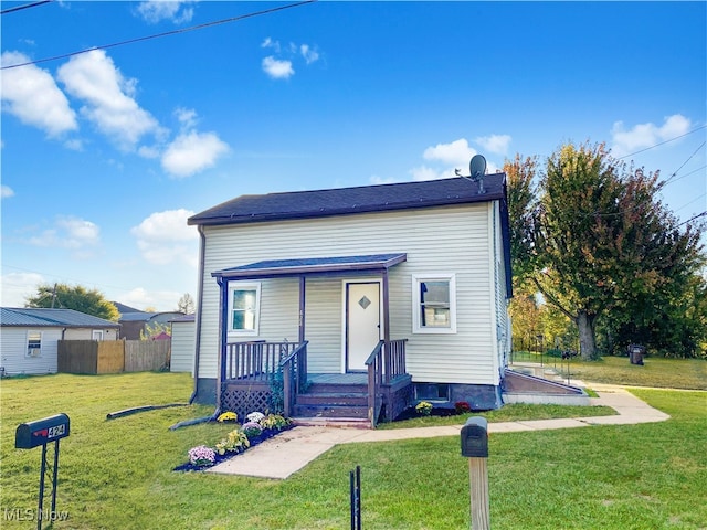 bungalow featuring covered porch and a front lawn