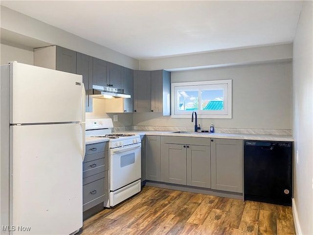 kitchen featuring dark hardwood / wood-style flooring, sink, gray cabinetry, and white appliances