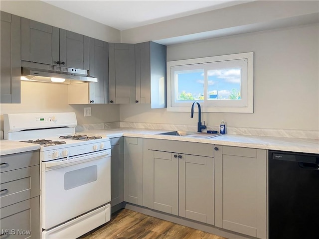 kitchen featuring sink, gas range gas stove, light hardwood / wood-style flooring, gray cabinets, and black dishwasher