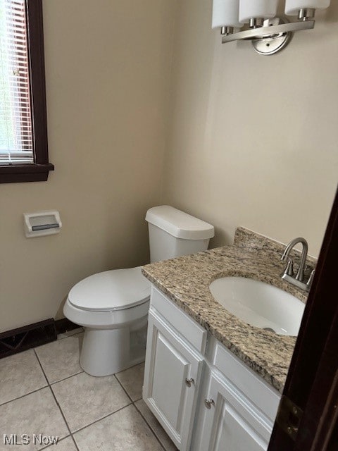 bathroom with tile patterned flooring, vanity, and toilet