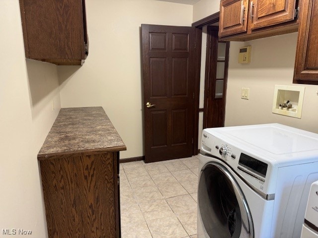 laundry area with cabinets, light tile patterned floors, and washer / clothes dryer