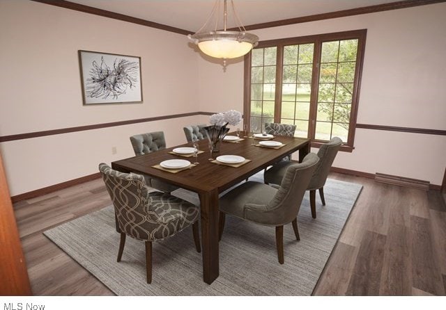 dining area with hardwood / wood-style floors and ornamental molding