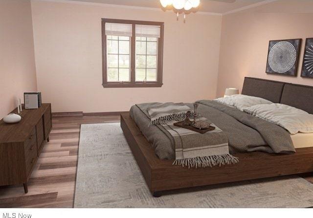 bedroom featuring crown molding and light wood-type flooring