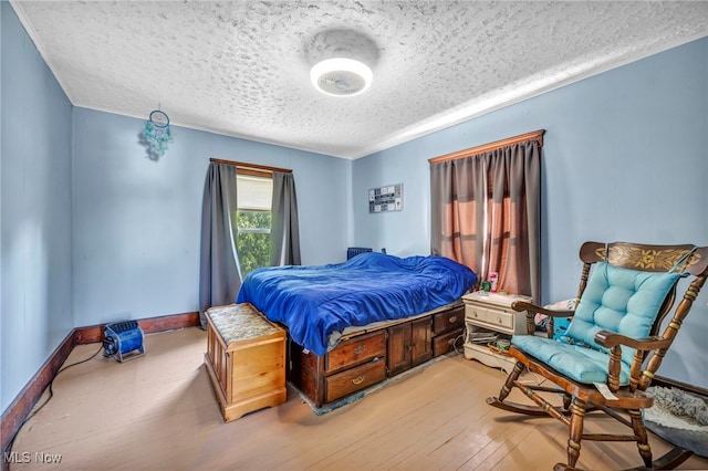 bedroom featuring light hardwood / wood-style flooring and a textured ceiling