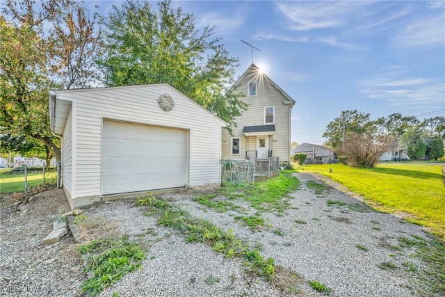 view of front of home with a front yard, an outbuilding, and a garage