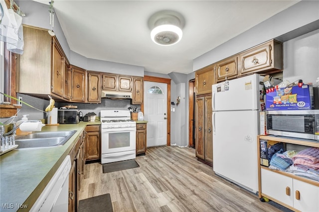 kitchen with decorative backsplash, sink, light wood-type flooring, and white appliances