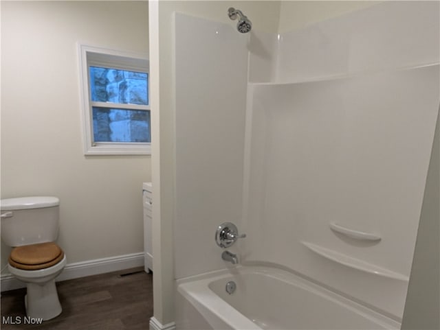 bathroom featuring toilet, hardwood / wood-style flooring, and shower / tub combination