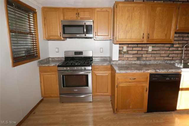 kitchen with stainless steel appliances, sink, and light wood-type flooring