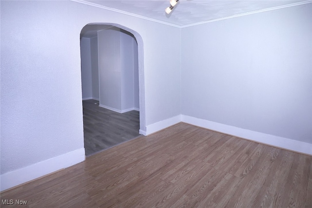 empty room with dark wood-type flooring and ornamental molding