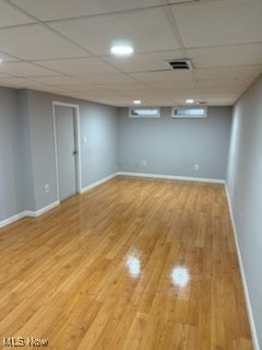 basement with hardwood / wood-style floors and a drop ceiling