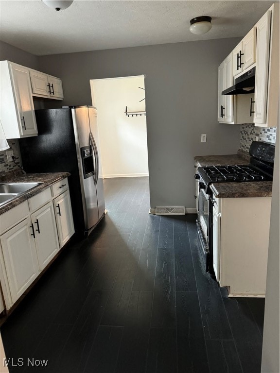 kitchen with white cabinets, backsplash, dark hardwood / wood-style flooring, sink, and stainless steel appliances