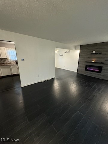 unfurnished living room featuring dark wood-type flooring