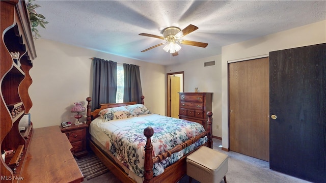 carpeted bedroom with a closet, a textured ceiling, and ceiling fan