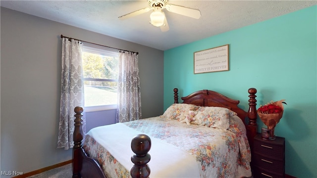 bedroom with ceiling fan and a textured ceiling