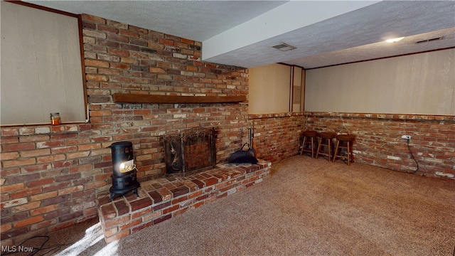 unfurnished living room with carpet flooring, brick wall, and a textured ceiling