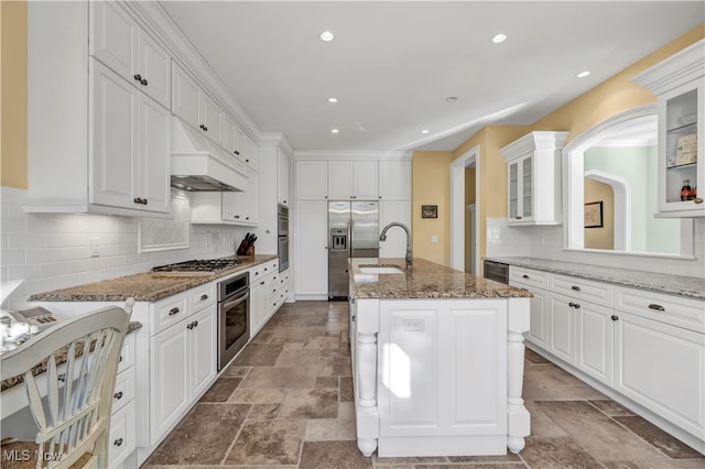 39470 Stillman Ln, Willoughby, OH 44094 - kitchen featuring white cabinetry, tasteful backsplash, stone counters, and an island with sink