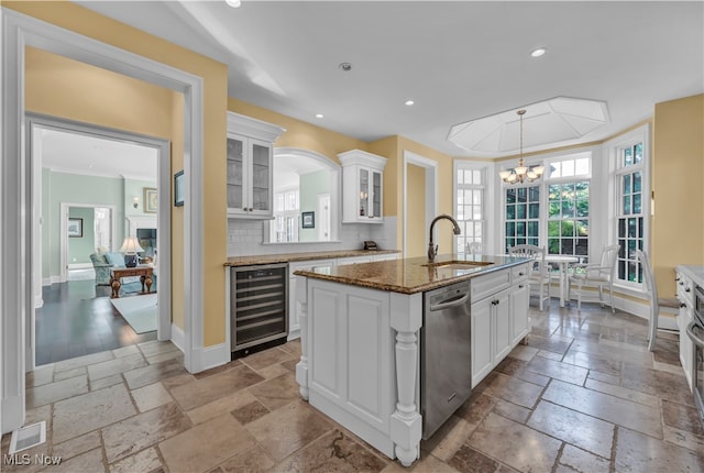 39470 Stillman Ln, Willoughby, OH 44094 - kitchen featuring sink, white cabinets, wine cooler, decorative backsplash, and a kitchen island with sink