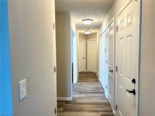 hall with hardwood / wood-style floors and a textured ceiling