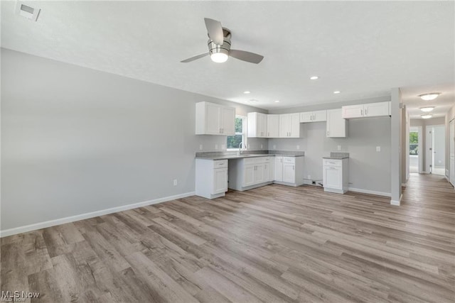 kitchen featuring white cabinets, light hardwood / wood-style floors, ceiling fan, and sink