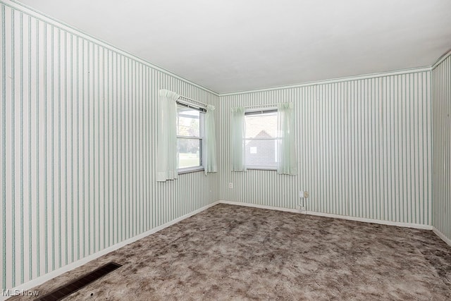 carpeted empty room featuring crown molding