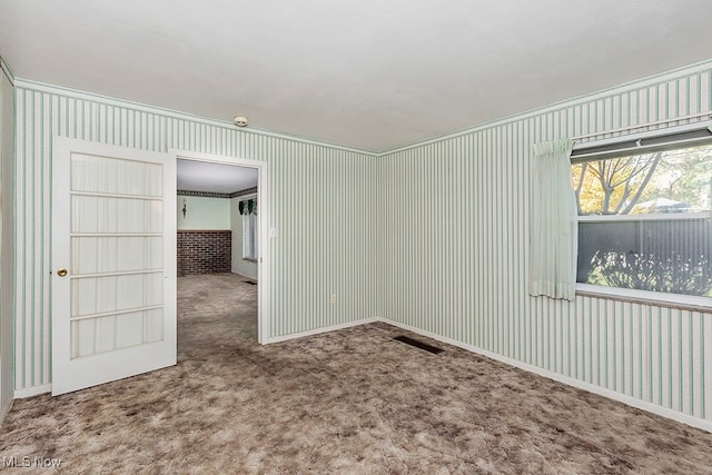 empty room featuring carpet flooring and ornamental molding