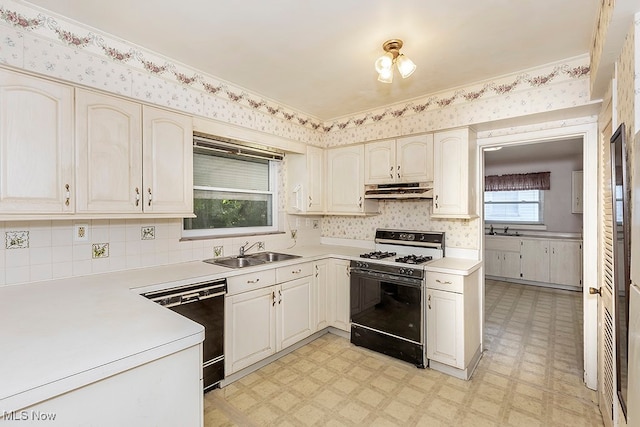 kitchen featuring a wealth of natural light, sink, black appliances, and decorative backsplash