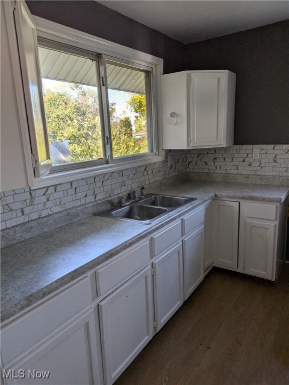 kitchen with white cabinetry, backsplash, and sink