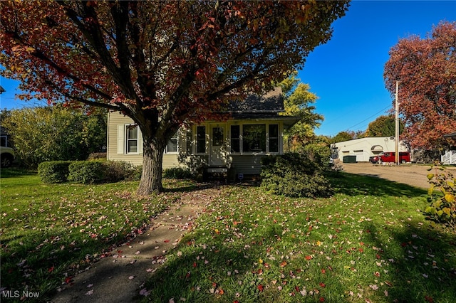 view of property hidden behind natural elements with a front lawn