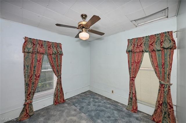 spare room featuring dark carpet and ceiling fan