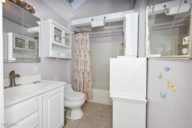 full bathroom with a skylight, shower / bath combo, toilet, vanity, and tile patterned flooring