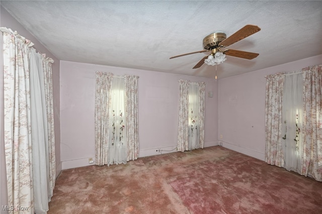 empty room featuring a textured ceiling, carpet flooring, and ceiling fan