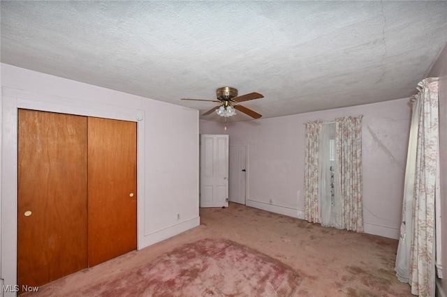 unfurnished bedroom with light carpet, a closet, a textured ceiling, and ceiling fan