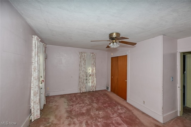 empty room featuring carpet, a textured ceiling, and ceiling fan