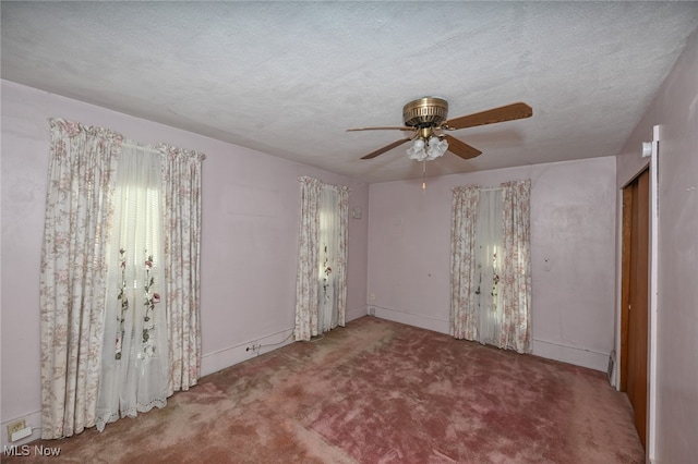 carpeted spare room with a textured ceiling and ceiling fan