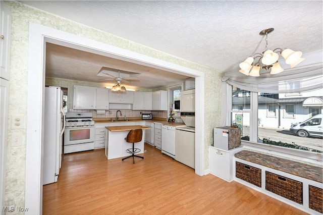 kitchen featuring white appliances, a textured ceiling, light hardwood / wood-style flooring, and sink