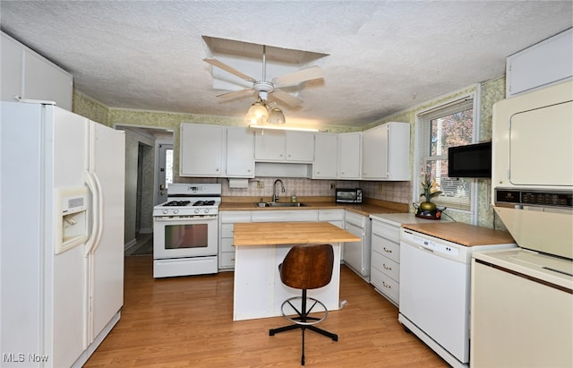 kitchen with white appliances, light hardwood / wood-style flooring, and white cabinets