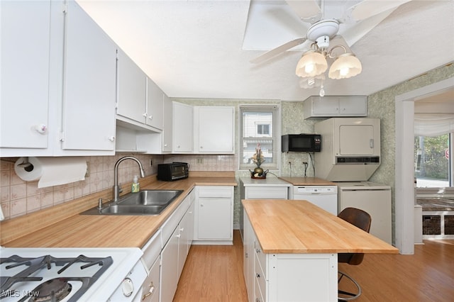 kitchen with light hardwood / wood-style flooring, wood counters, sink, white cabinets, and ceiling fan