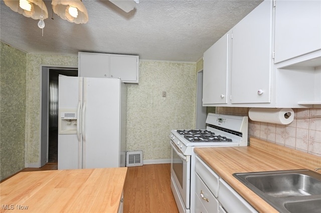 kitchen featuring sink, light wood-type flooring, white cabinets, white appliances, and ceiling fan