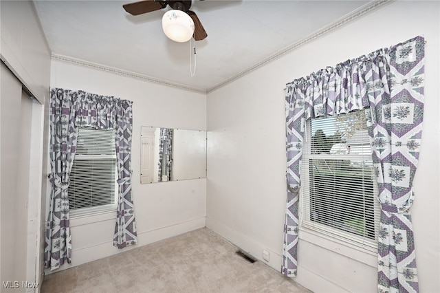 spare room featuring ceiling fan, ornamental molding, and carpet floors