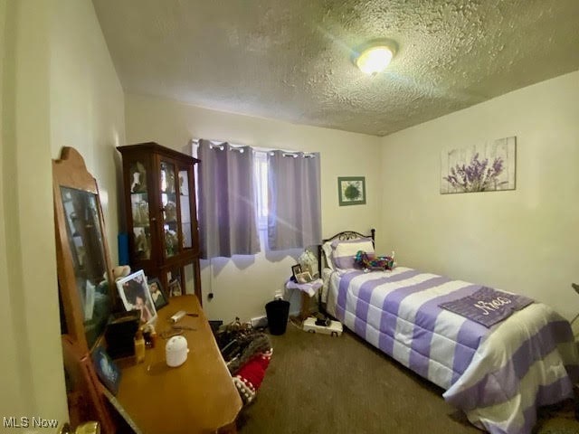 carpeted bedroom featuring a textured ceiling