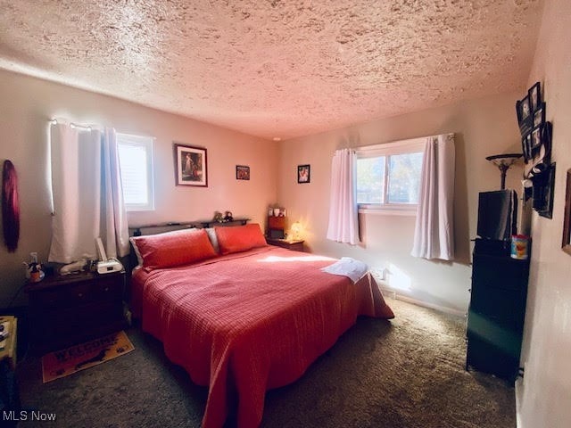 carpeted bedroom featuring a textured ceiling