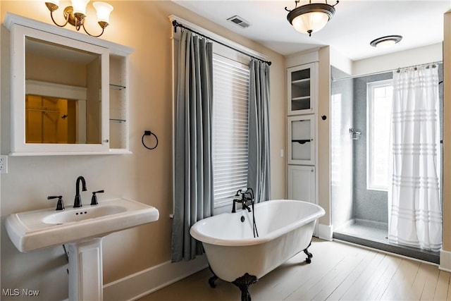 bathroom with hardwood / wood-style flooring and a tub to relax in