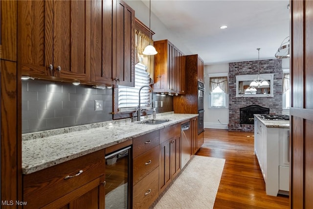 kitchen with sink, hanging light fixtures, stainless steel appliances, and wine cooler