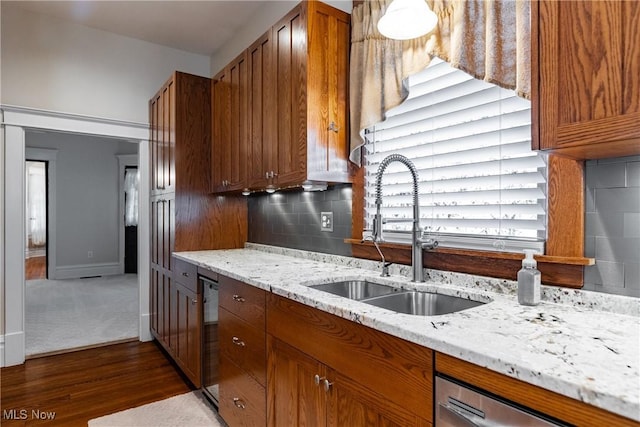 kitchen featuring stainless steel dishwasher, sink, tasteful backsplash, light stone counters, and black dishwasher