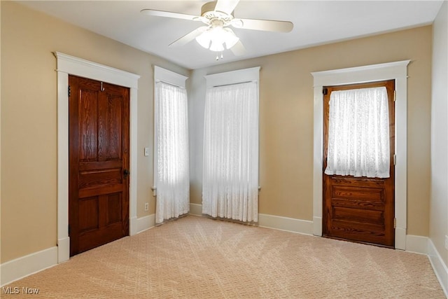 carpeted foyer entrance featuring ceiling fan