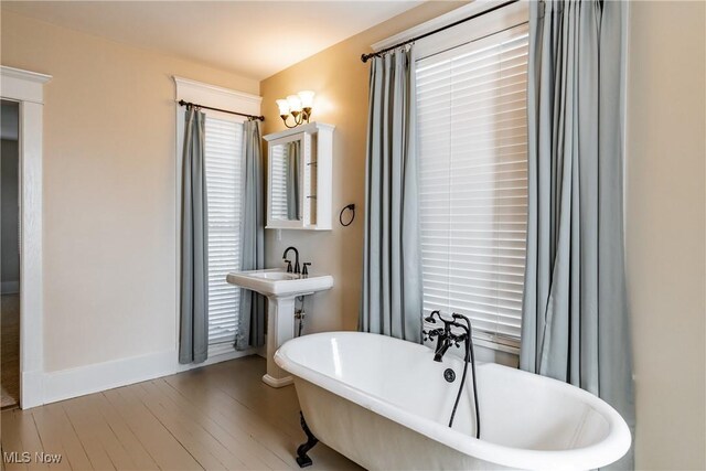 bathroom featuring sink, hardwood / wood-style flooring, and a bathing tub